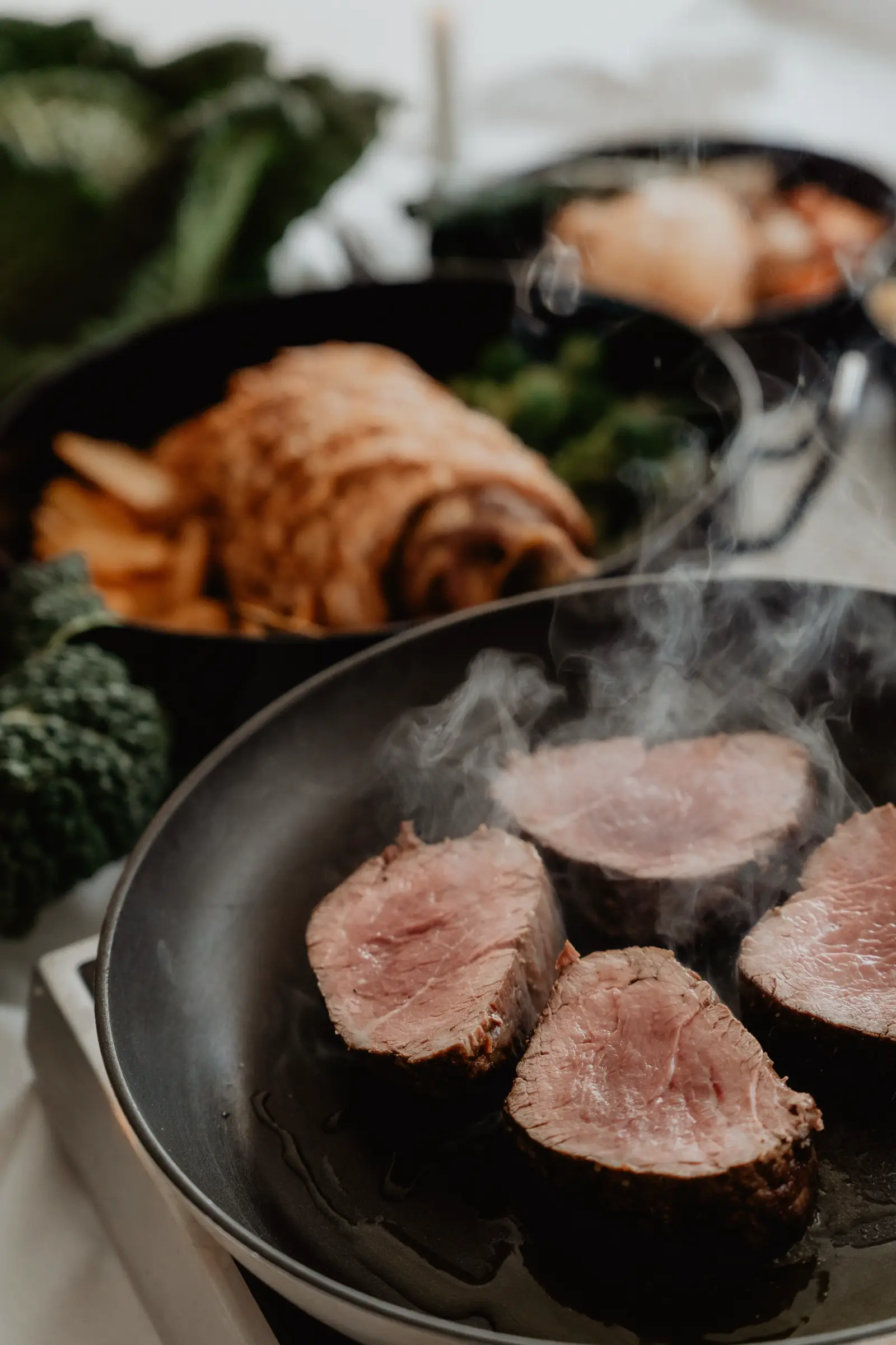 Close-up of perfectly seared gourmet beef steaks being prepared by Catering Majetic for a premium wedding menu.