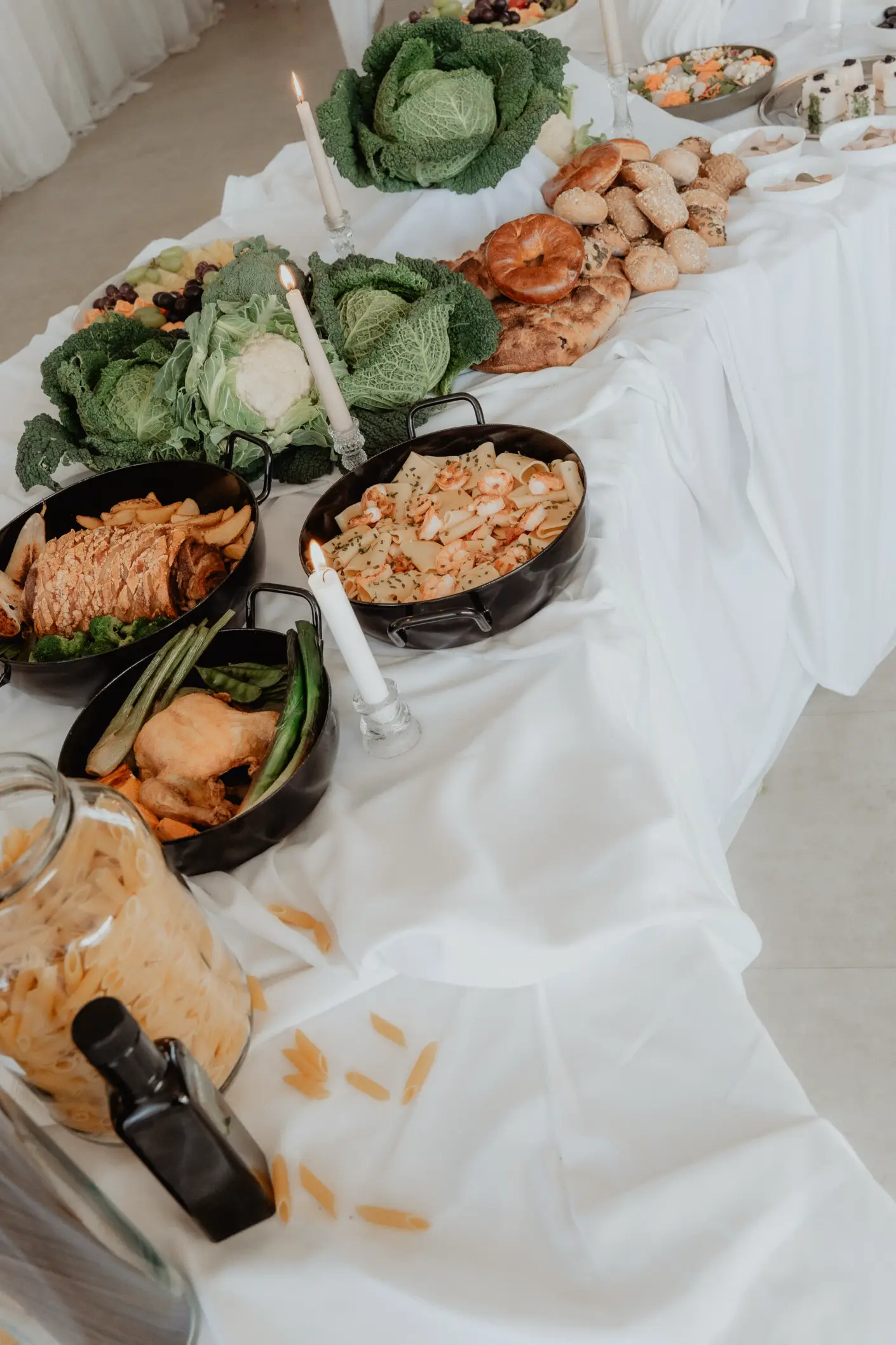 Sophisticated wedding buffet display by Catering Majetic, featuring a variety of hot dishes, fresh bread, and rustic decorative elements.
