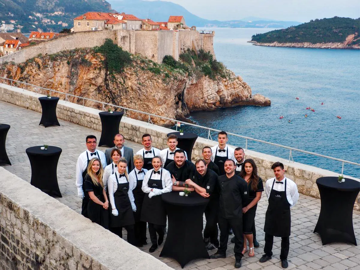 Catering Majetic team at an event in Dubrovnik with city walls in the background