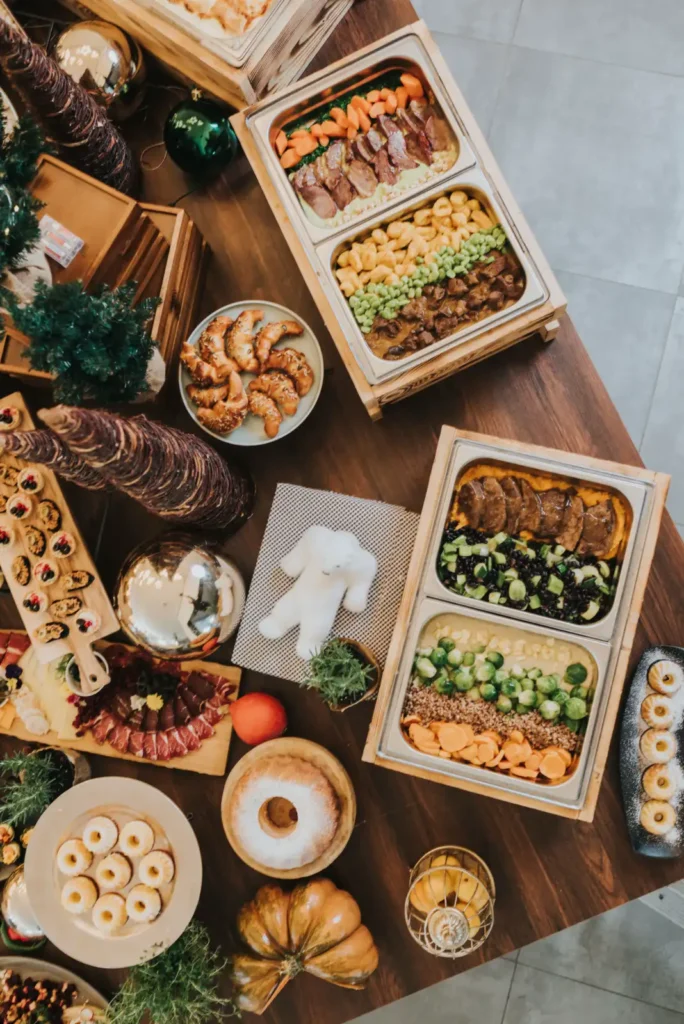Festive catering table with warm dishes and desserts at a Christmas party