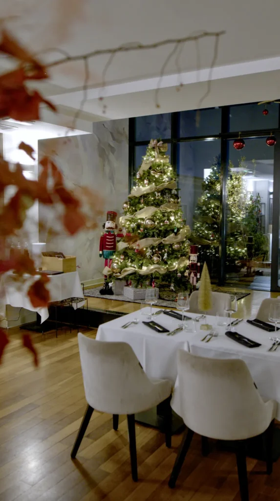 Christmas corporate event setup with decorated tree and dinner tables in Zagreb