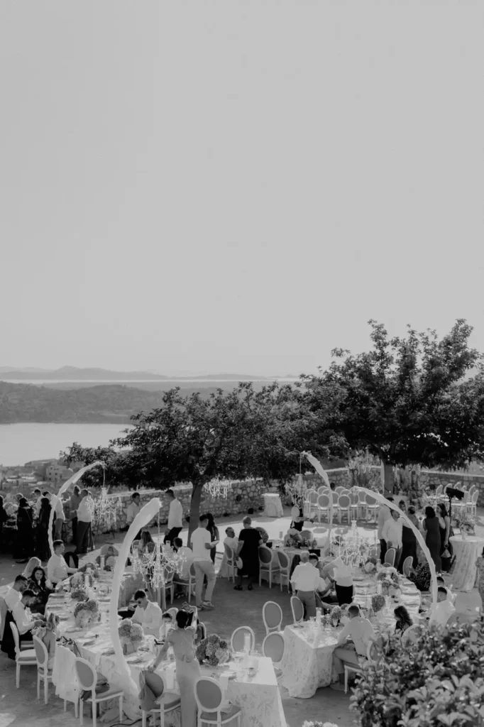 Artistic black and white aerial view of a luxury wedding reception by Catering Majetic at Barone Fortress, overlooking the stunning Sibenik bay.
