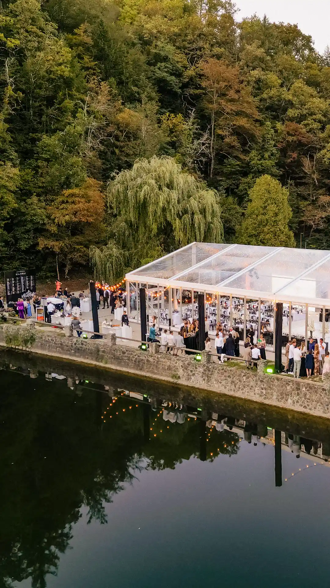 Luxury outdoor wedding reception with a transparent marquee tent by the lake near Trakoscan Castle, Croatia.